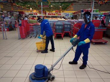 Equipa a limpar zona de padaria em supermercado